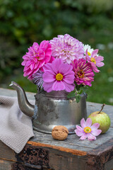 Blumenstrauß mit pink Schmuckkörbchen, Dahlien und Zinnie im alten Teekessel im Garten