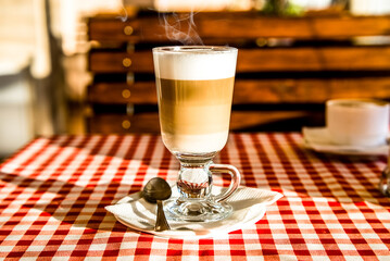 A Cup of coffee latte is on the table in the cafe
