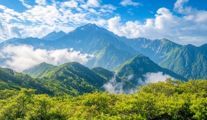 Obraz premium Lush green mountains stretch beneath a bright blue sky, with white clouds hovering over distant peaks in the morning sun