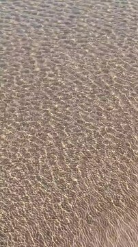 Texture de l'eau en arri&egrave;re-plan peu profond sur un fond de sable