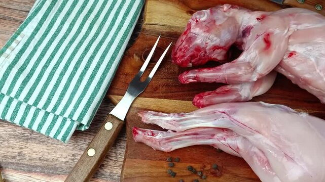 lapin entier, pr&ecirc;t &agrave; cuisiner, sur une planche &agrave; d&eacute;couper