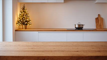 Empty wood kitchen table top for product display. Background with modern white kitchen with christmas tree and lights for product montage, mock-up, banner with copy space. Merry Christmas or New Year.