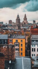 Yellow building stands out among rooftops with historic architecture in urban skyline on a cloudy day