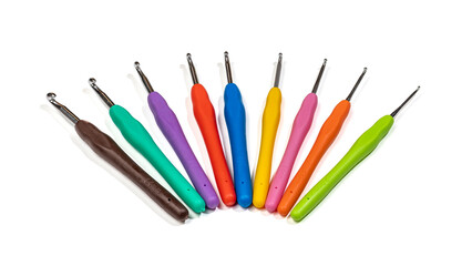 set of colorful metal crochet hooks with plastic handles in fan shape on white background