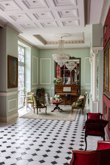 the chic expensive interior of the living room in the historical Baroque style, tiles on the floor, walls decorated with wood. the furniture is in a historical style.