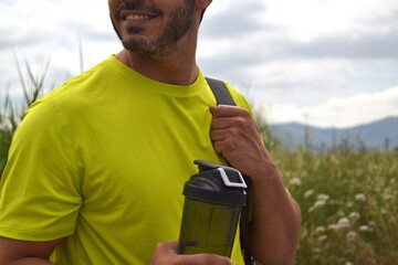 Young man drinking water while doing physical exercise. Hydration is very important to stay...