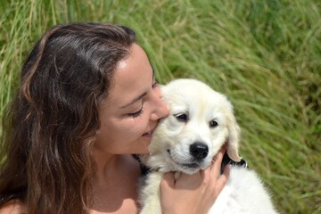 Young woman walking with her golden retriever puppy in her arms. Animal adoption. Life with a dog, with a golden retriever. Protect your pets. Man's best friend.