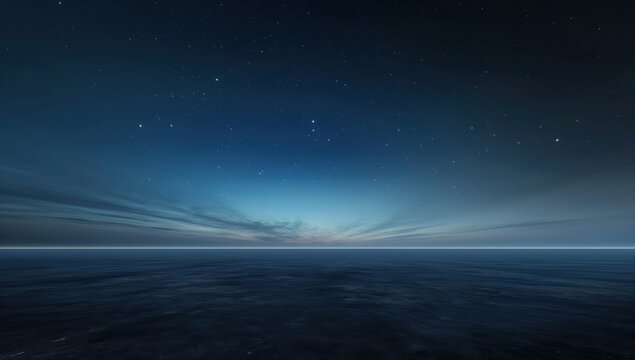 Dark blue sky with a few stars and a large body of water. The water is calm and the sky is clear