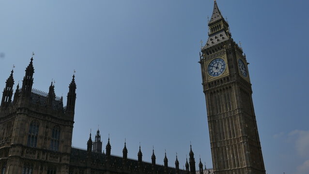 Sunny summer day in London, capturing the iconic Big Ben with clear skies. Showcasing the historic landmark's intricate architecture and its prominent place in the city's skyline.