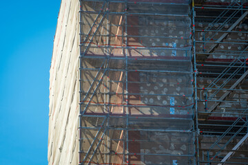 Scaffold sheeting net wrapped apartments building during insulation in england uk