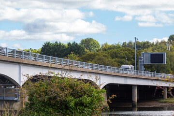 Motorway bridge in the UK, Image shows a bridge supporting the M27 over a river as traffic passes by on top on a cold Autumn day