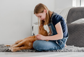 11-Year-Old Girl Plays With Nova Scotia Retriever Toller At Home On The Floor