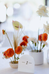 Elegant table centerpiece arrangement with seasonal flowers in a bright event setting