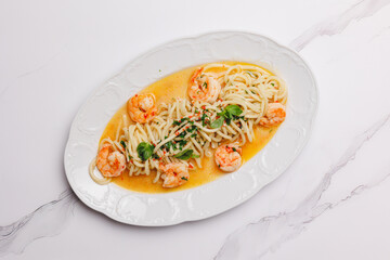 Spaghetti with seafood and cream sauce on a large white plate.