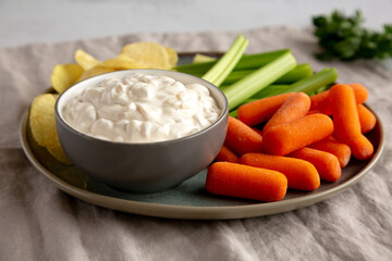 Homemade Carmelized Onion Dip with Baby Carrots, Chips and Celery, side view.