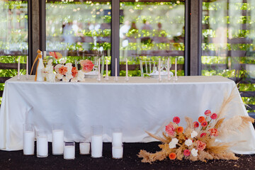 Elegant wedding reception table adorned with flowers and candles set in a garden venue