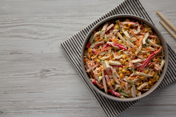 Homemade Japanese Kani Salad with Crab Sticks and Vegetables on a Plate, top view. Copy space.