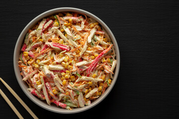 Homemade Japanese Kani Salad with Crab Sticks and Vegetables on a Plate, top view. © Liudmyla