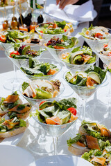 Colorful appetizer display featuring gourmet salads at a catered outdoor event during daytime