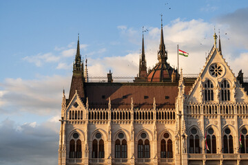 Fototapeta premium Detail of the Parliament building in Budapest and waving flag, Hungary