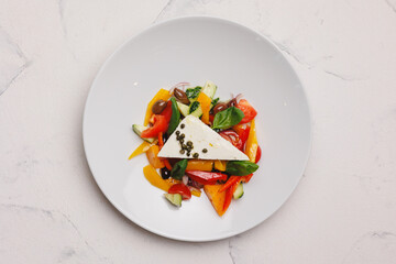 Greek salad on a large white plate. Restaurant food service, brunch, lunch, banquet.