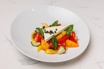 Greek salad on a large white plate. Restaurant food service, brunch, lunch, banquet.