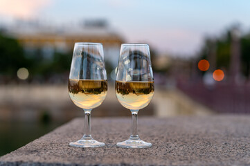 Sherry wine tasting on roof of old Triana district in Sevilla with view on Sevilla houses and river, wine glasses
