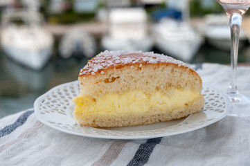 Cake of French Riviera, Tarte Tropezienne cake in yacht harbour of Port Grimaud, summer vacation in Provence, France