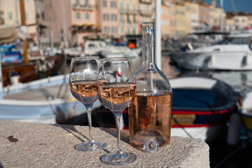 Glasses of cold rose Cote de Provence wine in old fisherman boats and yacht harbour in Saint-Tropez, summer vacation on French Riviera in Provence, France