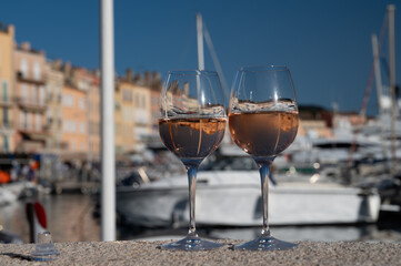 Glasses of cold rose Cote de Provence wine in old fisherman boats and yacht harbour in Saint-Tropez, summer vacation on French Riviera in Provence, France