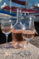 Glasses of cold rose Cote de Provence wine in old fisherman boats and yacht harbour in Saint-Tropez, summer vacation on French Riviera in Provence, France