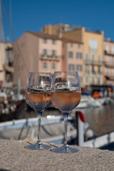 Glasses of cold rose Cote de Provence wine in old fisherman boats and yacht harbour in Saint-Tropez, summer vacation on French Riviera in Provence, France