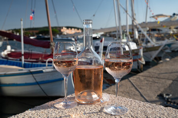 Glasses of cold rose Cote de Provence wine in old fisherman boats and yacht harbour in Saint-Tropez, summer vacation on French Riviera in Provence, France