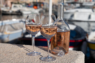 Glasses of cold rose Cote de Provence wine in old fisherman boats and yacht harbour in Saint-Tropez, summer vacation on French Riviera in Provence, France