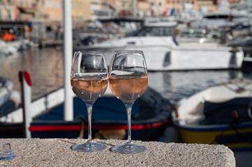 Glasses of cold rose Cote de Provence wine in old fisherman boats and yacht harbour in Saint-Tropez, summer vacation on French Riviera in Provence, France