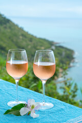 Summer time in Provence, two glasses of cold rose wine with blue sea view on background, French Riviera near Menton, south of France
