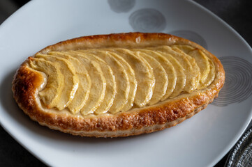 French fresh baked sweet puff pastry with fresh apple fruits in sirup in confectionery shop