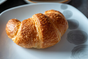 Fresh baked two buttered croissants served in restaurant for continental or French breakfast close up