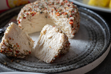 French cheese collection, fresh white soft goat cheese with aromatic herbs, garlic, parsley and red peppers close up