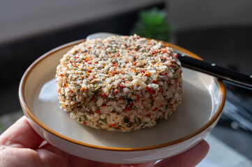 French cheese collection, fresh white soft goat cheese with aromatic herbs, garlic, parsley and red peppers close up