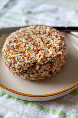 French cheese collection, fresh white soft goat cheese with aromatic herbs, garlic, parsley and red peppers close up