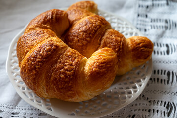 Fresh baked two buttered croissants served in restaurant for continental or French breakfast close up
