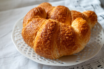 Fresh baked two buttered croissants served in restaurant for continental or French breakfast close up