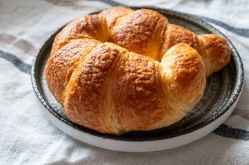Fresh baked two buttered croissants served in restaurant for continental or French breakfast close up