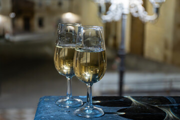 Sherry wine glasses with fino and old church on background at night in Jerez de la Frontera, wine glasses outdoor, cityview, Andalusia, Spain