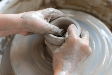Making of mud pot on potters wheel during workshop in art ceramic atelier in Poland
