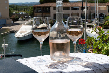 Glasses of cold rose gris Cote de Provence wine in yacht harbour of Port Grimaud, summer vacation on French Riviera in Provence, France