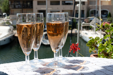 Summer party, French brut rose champagne sparkling wine in flute glasses in yacht harbour of Port Grimaud near Saint-Tropez, French Riviera vacation, Var, France