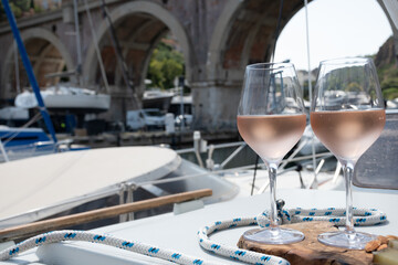 Party with rose wine on yacht boat anchored in port la Rague, Gulf of La Napoule, in Provence, two glasses of cold rose wine, French Riviera near Cannes, south of France