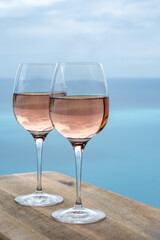 Summer time in Provence, two glasses of cold rose wine with blue sea view on background, French Riviera near Menton, south of France